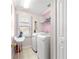 Bright laundry room with front load washer and dryer, and storage at 30549 Pga Dr, Sorrento, FL 32776