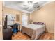 Bedroom with a queen bed, ceiling fan, and workspace at 30549 Pga Dr, Sorrento, FL 32776