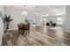 Open living room and dining area with wood-look floors and lots of natural light at 5701 Blanchard Ln, The Villages, FL 32163