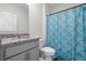 Clean bathroom with granite countertop, shower, and blue patterned curtain at 1565 Tali Ln, Mount Dora, FL 32757