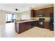 Open kitchen with island, dark wood cabinets and black appliances at 34416 Tuscany Ave, Sorrento, FL 32776
