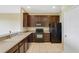 Modern kitchen featuring dark wood cabinets and black appliances at 34416 Tuscany Ave, Sorrento, FL 32776