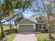 Gray house with gray garage door and stone accents, on a tree-lined street at 34416 Tuscany Ave, Sorrento, FL 32776