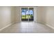 Living room with tile floor, sliding glass doors to patio at 34416 Tuscany Ave, Sorrento, FL 32776