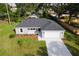 New construction home with gray exterior, white garage door, and landscaped yard at 1366 Peters Dr, Leesburg, FL 34748