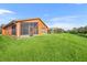 Landscaped backyard showcasing a home with screened patio and conservation view at 540 Grand Canal Dr, Kissimmee, FL 34759