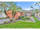 Single story house with orange exterior, paver driveway and landscaping at 540 Grand Canal Dr, Kissimmee, FL 34759
