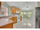 Kitchen with wood cabinets, white appliances, and tile floors at 540 Grand Canal Dr, Kissimmee, FL 34759