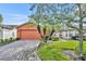 Single-story house with orange exterior, paver driveway, and landscaping at 540 Grand Canal Dr, Kissimmee, FL 34759