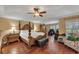 Large main bedroom with a comfortable king-size bed and hardwood floors at 13129 Coldwater Loop, Clermont, FL 34711