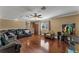 Open living area with hardwood floors, leather sectional sofa, and large TV at 13129 Coldwater Loop, Clermont, FL 34711