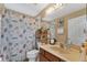 Bathroom with seashell shower curtain and wood vanity at 13129 Coldwater Loop, Clermont, FL 34711