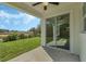 Covered patio with sliding glass doors, overlooking a grassy backyard and pond at 12332 Basin St, Clermont, FL 34715
