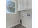 Laundry room with white cabinets and a window offering natural light at 12332 Basin St, Clermont, FL 34715