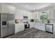 Modern kitchen boasts white shaker cabinets, stainless steel appliances, and grey flooring at 12332 Basin St, Clermont, FL 34715