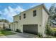Two-story house with a white exterior, dark garage door, and a landscaped yard at 12332 Basin St, Clermont, FL 34715