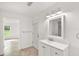 Clean bathroom with white vanity, mirror and access to exterior at 8222 Florida Boys Ranch Rd, Groveland, FL 34736