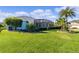Landscaped backyard oasis with screened patio and lush lawn at 25304 Forest Oak Ct, Leesburg, FL 34748