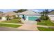 One-story home with teal exterior, landscaping, and driveway at 25304 Forest Oak Ct, Leesburg, FL 34748