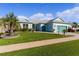 Charming light blue home with teal garage doors and lush landscaping at 25304 Forest Oak Ct, Leesburg, FL 34748