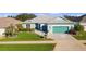 Beautiful teal home with lush landscaping and a paved driveway at 25304 Forest Oak Ct, Leesburg, FL 34748
