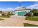 House exterior, teal color, landscaping, and driveway at 25304 Forest Oak Ct, Leesburg, FL 34748
