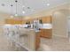 Modern kitchen with light wood cabinets, stainless steel appliances, and an island with seating at 25304 Forest Oak Ct, Leesburg, FL 34748