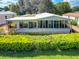 Single story home with large sunroom addition and lush landscaping at 645 Rainbow Blvd, The Villages, FL 32159