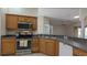Modern kitchen with stainless steel appliances, oak cabinets, and plenty of counter space at 17755 Se 85Th Ellerbe Ave, The Villages, FL 32162