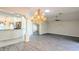 Spacious living room with wood-look flooring, chandelier, and ceiling fan at 17755 Se 85Th Ellerbe Ave, The Villages, FL 32162