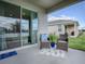 Covered patio with wicker furniture and lake view at 5035 Stokes Way, Wildwood, FL 34785