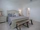 Elegant Primary bedroom with a king-size bed and a bench at the foot at 5035 Stokes Way, Wildwood, FL 34785