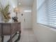 Bright entryway with tiled floor, white door, and decorative console table at 5035 Stokes Way, Wildwood, FL 34785