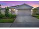 Two-story house with beige siding, neutral accents, and a two-car garage at 5035 Stokes Way, Wildwood, FL 34785