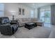 Relaxing living room with comfortable seating, a large TV and access to patio at 5035 Stokes Way, Wildwood, FL 34785