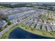 Aerial view of a new residential development with pond and roads at 5035 Stokes Way, Wildwood, FL 34785