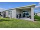 Home exterior with covered patio and backyard at 5035 Stokes Way, Wildwood, FL 34785