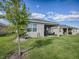 Home exterior with covered patio and lawn at 5035 Stokes Way, Wildwood, FL 34785
