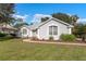 Single-story home with grey exterior, white shutters, and well-maintained landscaping at 39112 Treeline Dr, Lady Lake, FL 32159