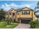 Stunning two-story house with a yellow exterior, brown accents, and a two-car garage at 349 Morning View Dr, Winter Garden, FL 34787