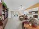 Open concept living area with L-shaped sofa, fireplace, and access to back patio at 32857 Timberwood Dr, Leesburg, FL 34748