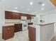Modern kitchen with dark wood cabinets, granite countertops, and white appliances at 32857 Timberwood Dr, Leesburg, FL 34748