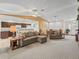 Open concept living room with vaulted ceiling, a large L-shaped couch and a dining area at 32857 Timberwood Dr, Leesburg, FL 34748
