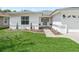 Landscaped front yard with walkway leading to the entrance of a house at 32857 Timberwood Dr, Leesburg, FL 34748