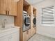 Laundry room with modern washer, dryer, and built-in cabinets at 16820 Bolsena Dr, Bella Collina, FL 34756