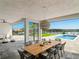 Covered patio with large dining table, comfortable seating, and pool view at 16820 Bolsena Dr, Bella Collina, FL 34756