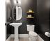 Stylish bathroom with pedestal sink and dark-colored walls at 16820 Bolsena Dr, Bella Collina, FL 34756