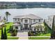 Lakefront home with modern architecture and landscaped yard at 16820 Bolsena Dr, Bella Collina, FL 34756
