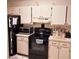 Kitchen with white cabinets, black appliances, and countertops at 6116 Curry Ford Rd # 229, Orlando, FL 32822