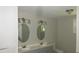 Updated bathroom with double vanity and oval mirrors at 214 W Dade Ave, Bushnell, FL 33513